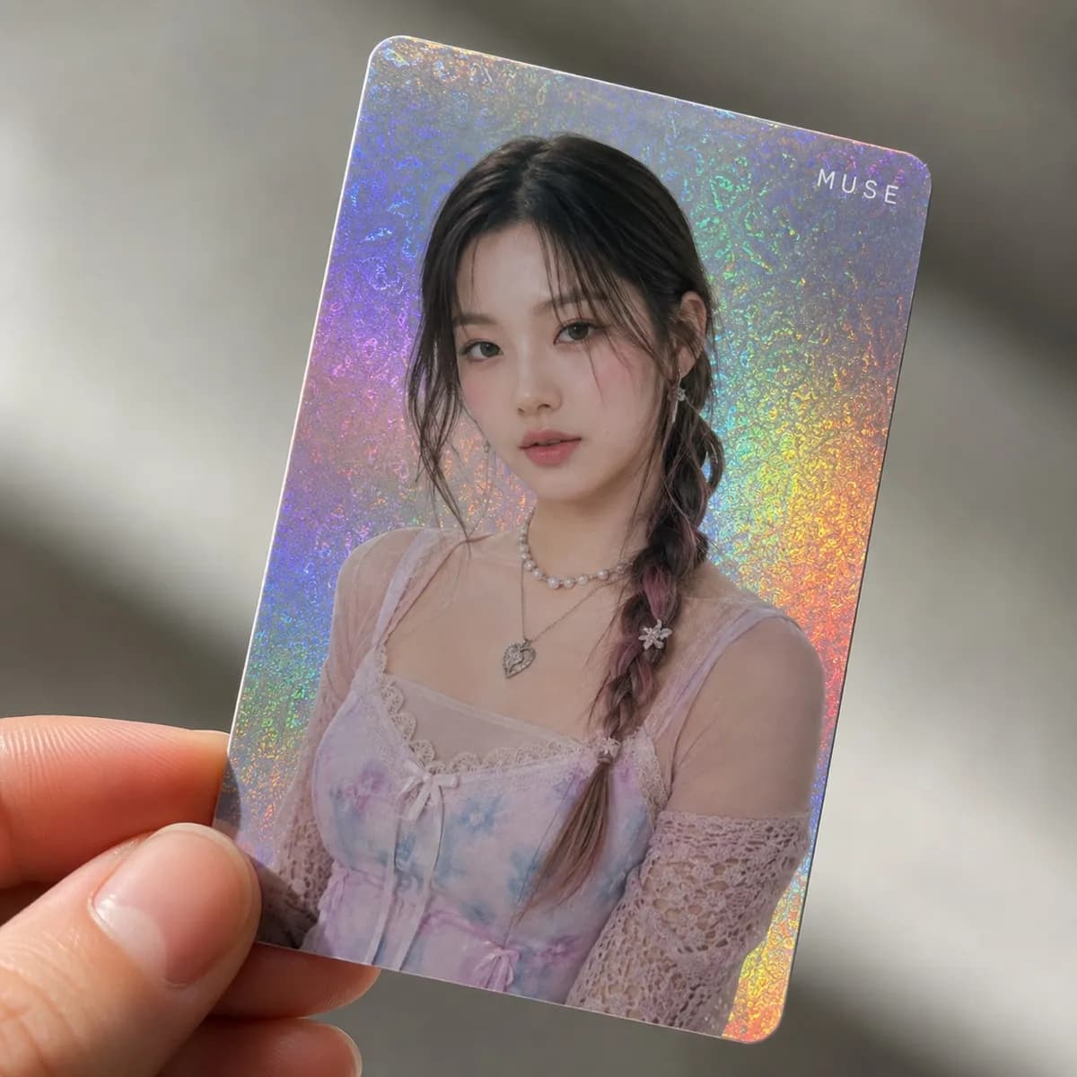 Close-up of a holographic photocard held in hand